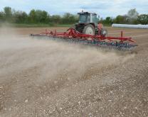 tracteur trainant une herse étrille en post-semis/pré-levée du maïs